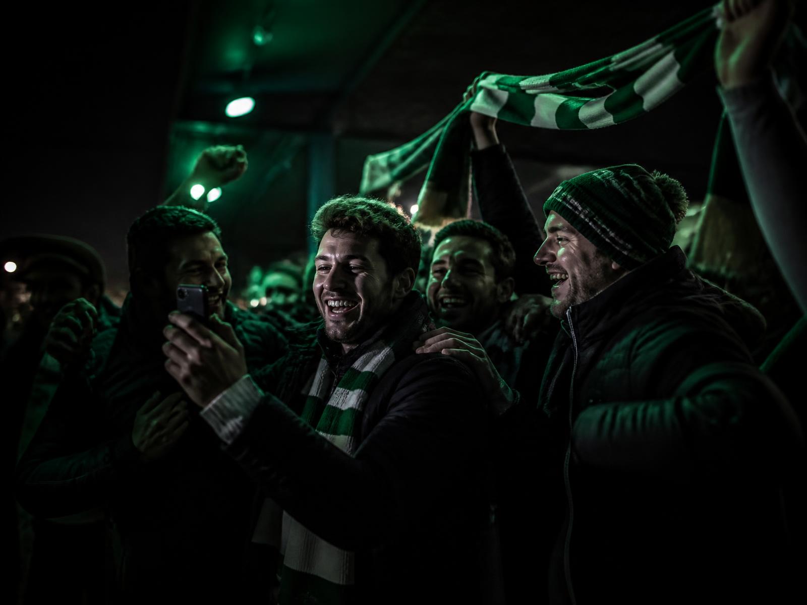 Un tifoso fermo nell'atrio illuminato dello stadio mentre la folla si muove intorno a lui